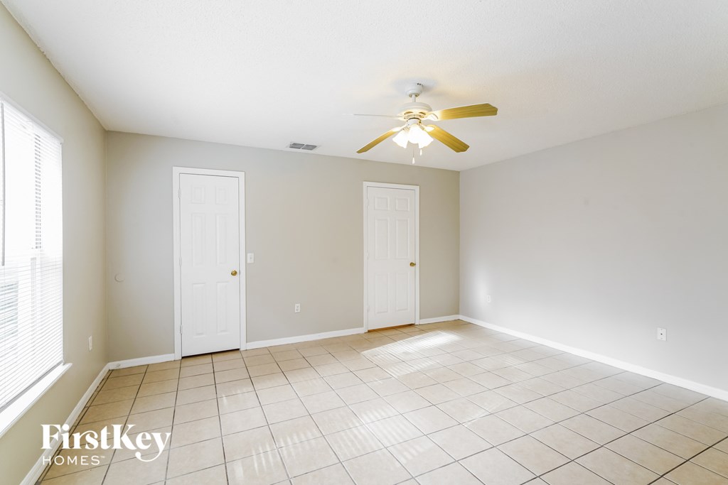 a clean and empty living room with a ceiling fan