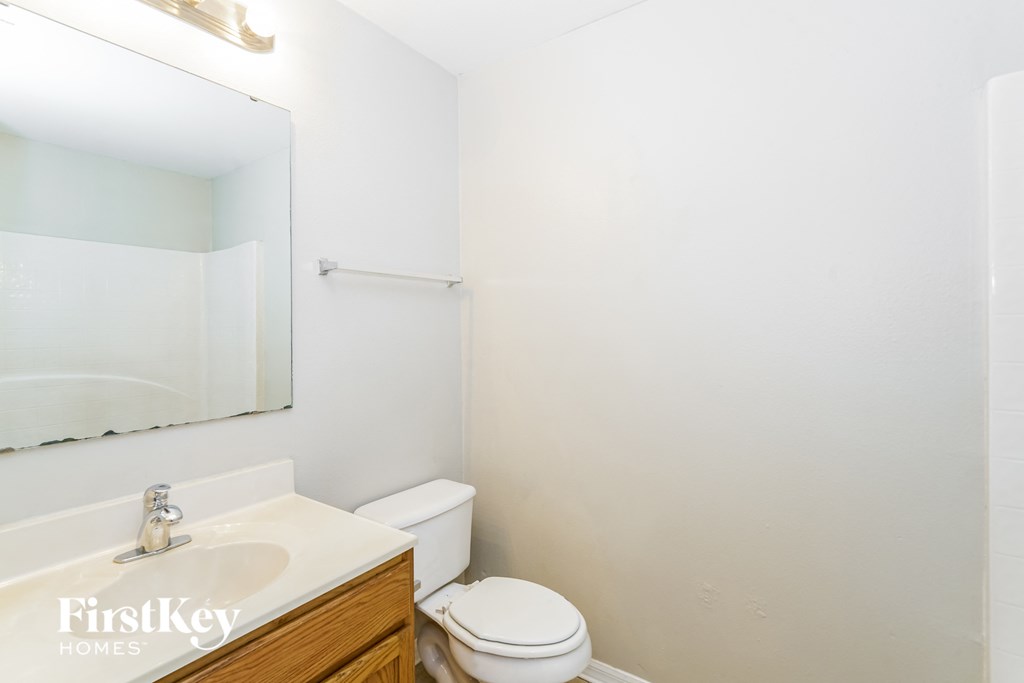 a bathroom with a toilet and a sink and a mirror