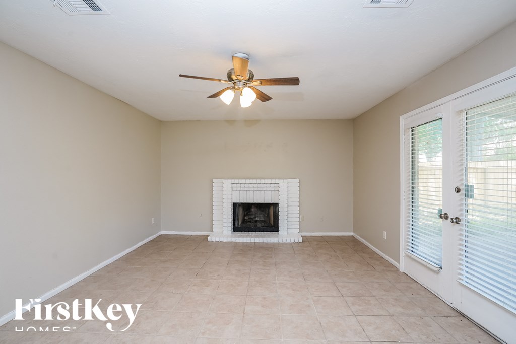 a living room with a fireplace and a ceiling fan