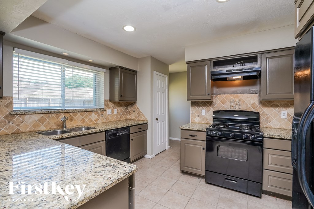 an updated kitchen with granite counter tops and stainless steel appliances