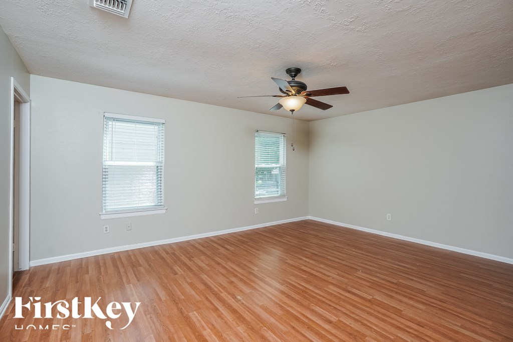 a living room with wood floors and a ceiling fan