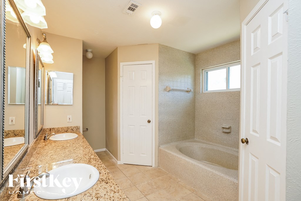 a bathroom with a tub and a sink and a mirror