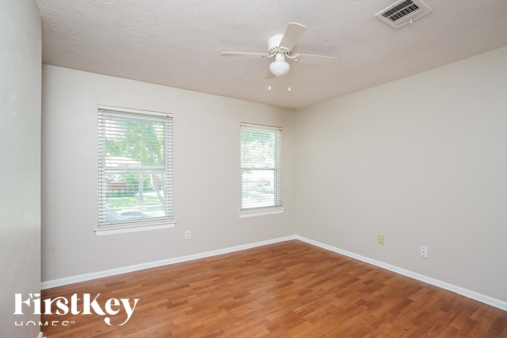 a living room with wood floors and a ceiling fan