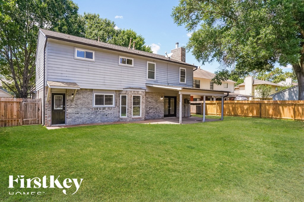 a backyard with a stone house and a wooden fence