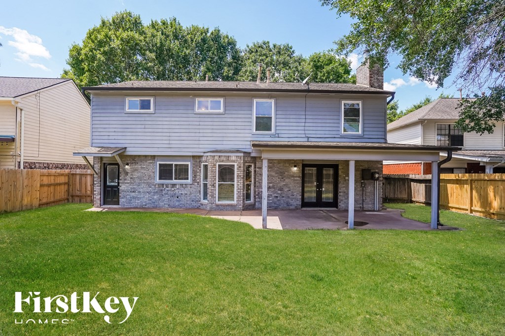 a blue house with a yard and a patio
