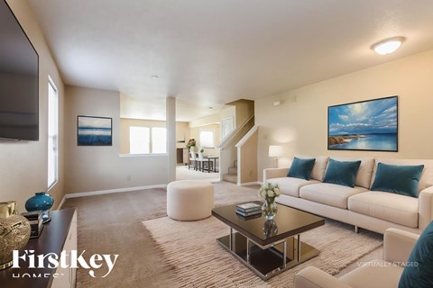 A living room with a couch, coffee table, and a painting on the wall.