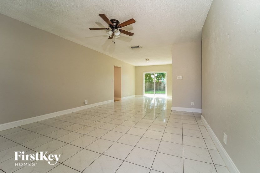 A spacious room with a ceiling fan and tiled floor.