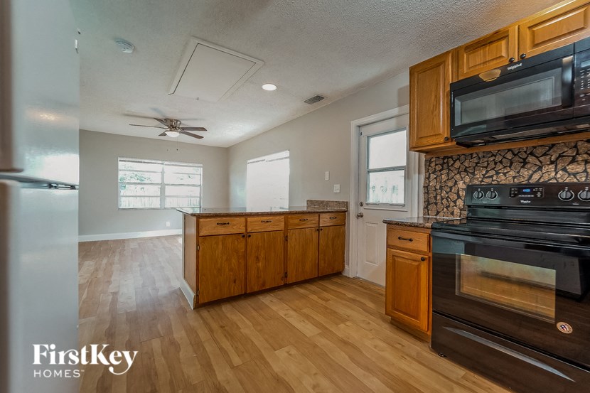 A kitchen with wooden cabinets and a black stove top oven.