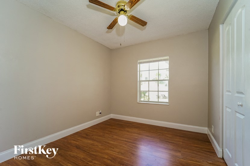 A room with a ceiling fan and a window.
