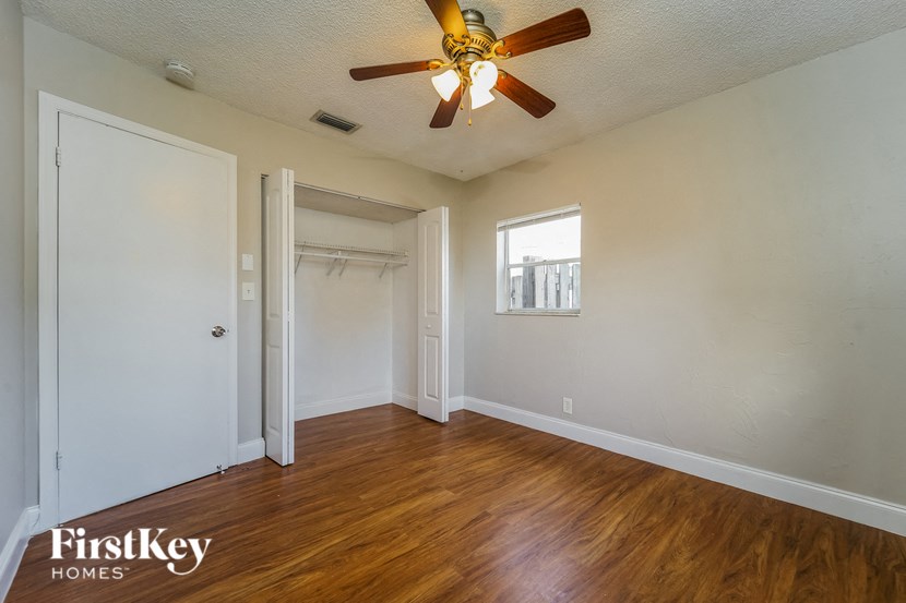 A room with a ceiling fan and wooden floors.
