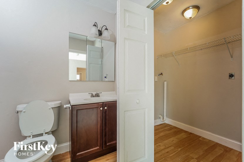 A bathroom with a toilet, sink, and mirror.