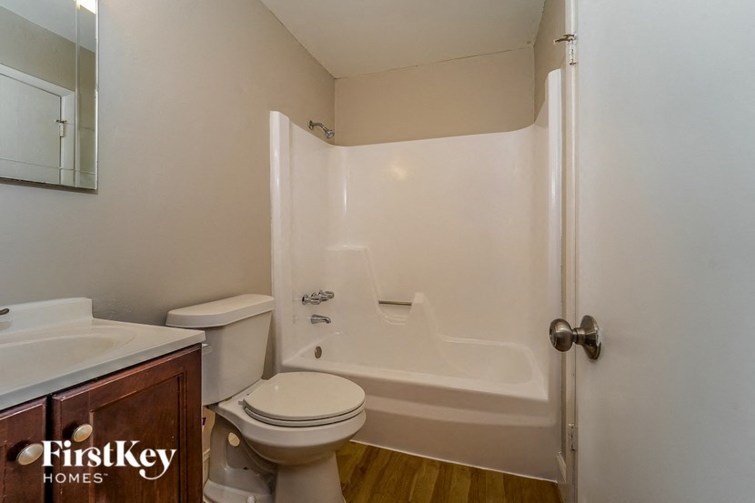 A white bathroom with a toilet, sink, and bathtub.
