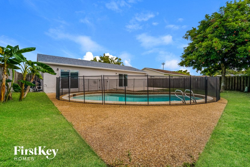 A house with a pool and a fence.