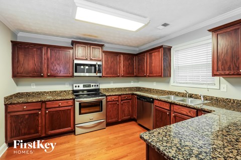 A kitchen with wooden cabinets and granite countertops.