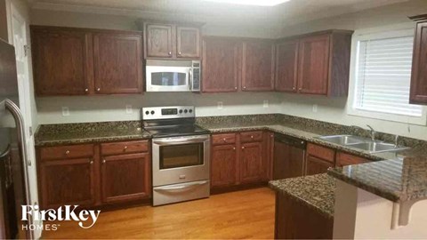 A kitchen with wooden cabinets and granite countertops.