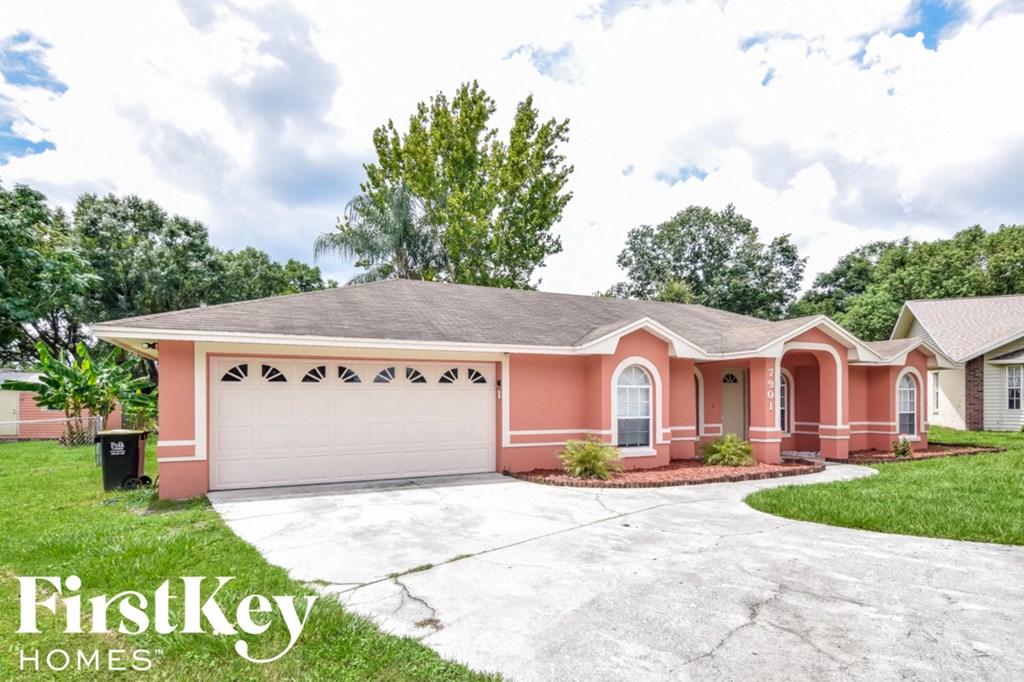 a pink house with a garage and a driveway