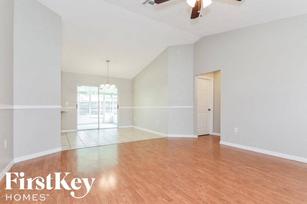 an empty living room with a hardwood floor and white walls