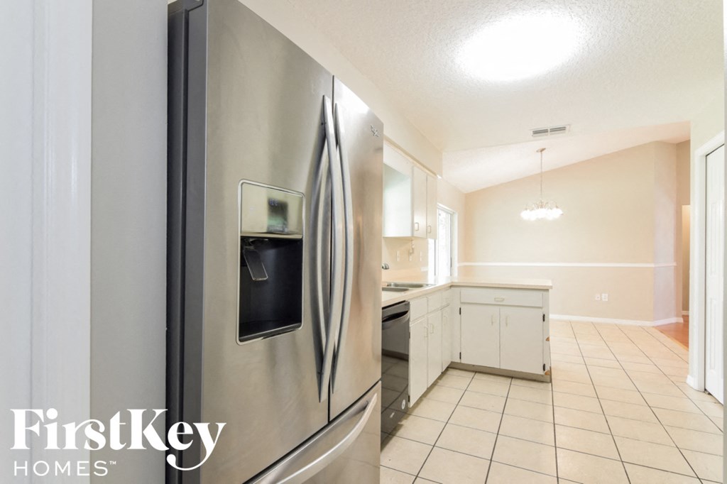 a kitchen with a stainless steel refrigerator and white cabinets