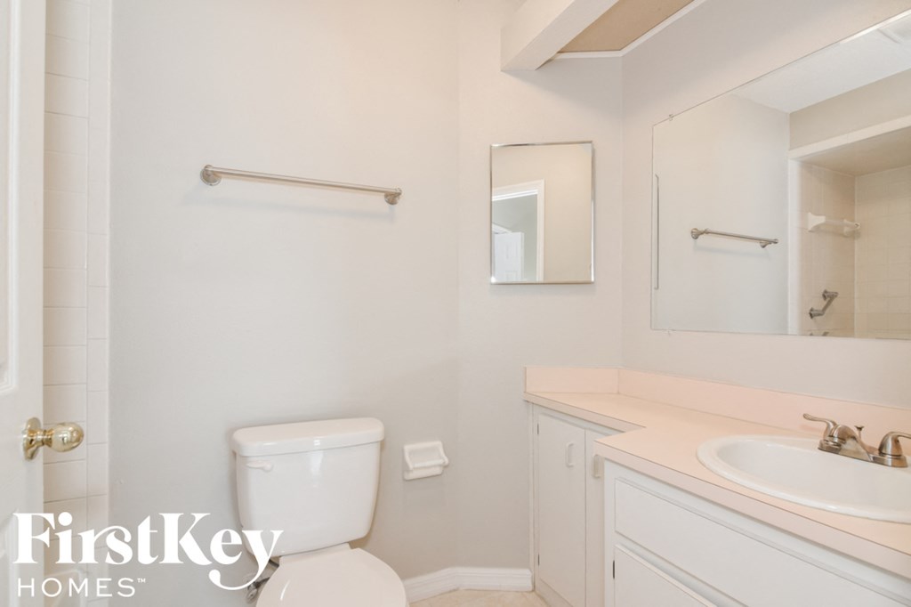 a white bathroom with a toilet and a sink