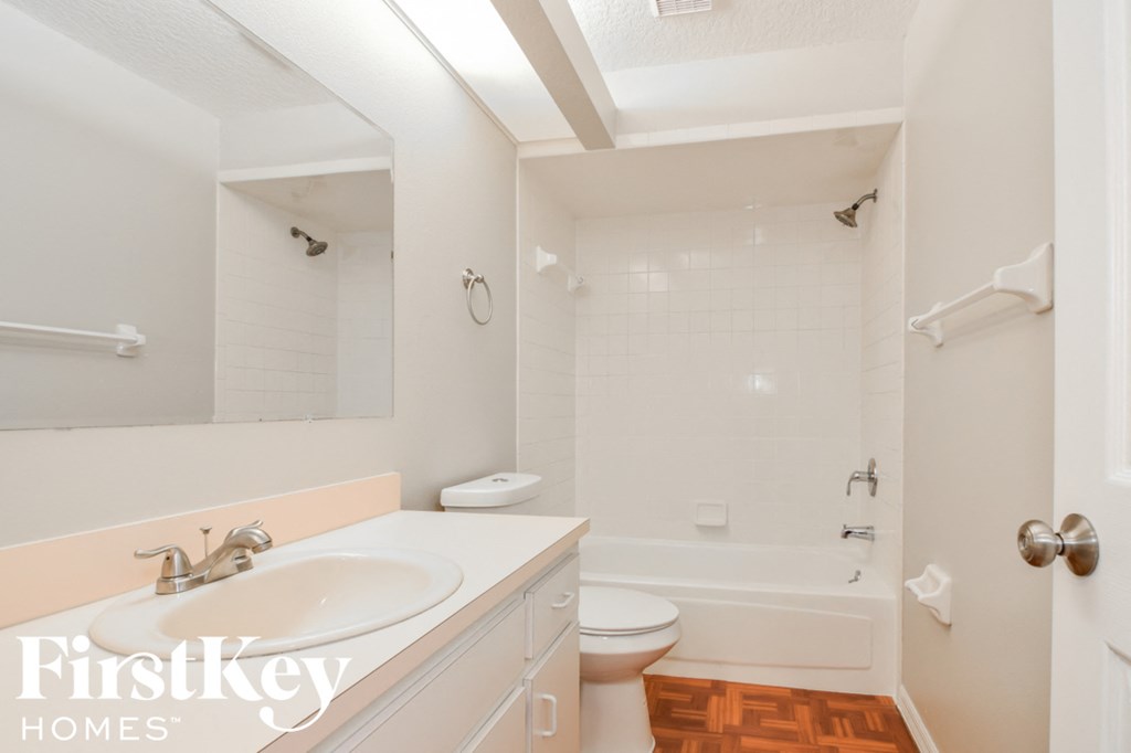 a white bathroom with a sink and a toilet