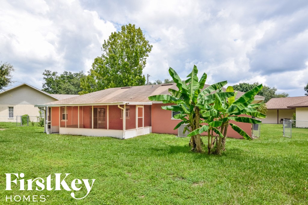 a cute pink house with a banana tree in the yard