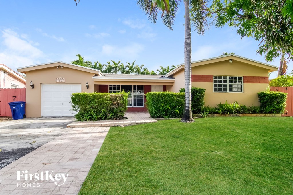 a home with a lawn and palm tree in front of it