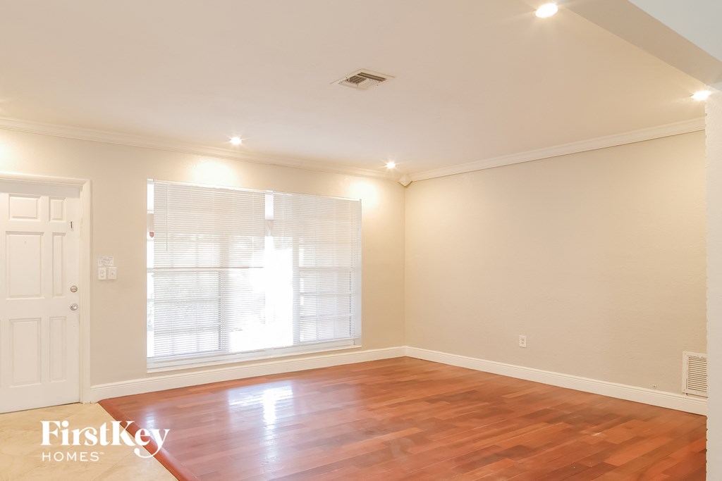 the living room with wood floors and a large window