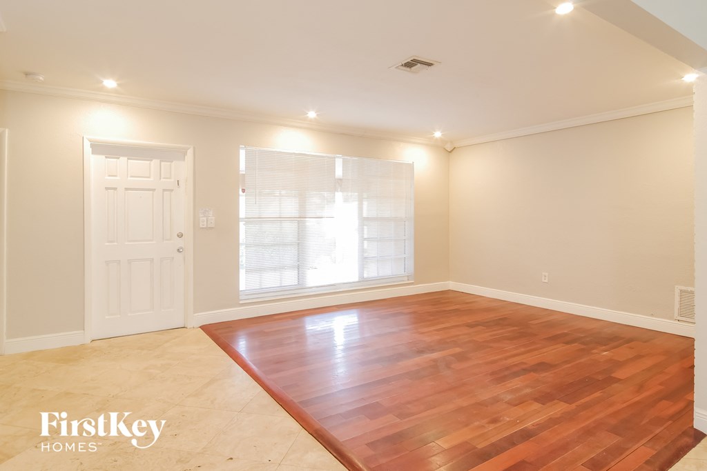 a living room with a wooden floor and a white door