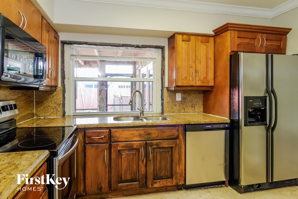a kitchen with wooden cabinets and stainless steel appliances and a window