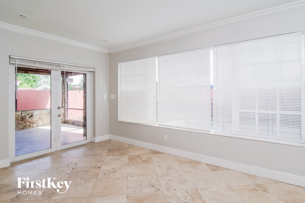 a living room with large windows and a door to a patio