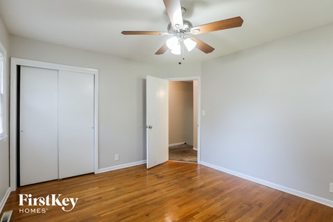 a living room with wood floors and a ceiling fan