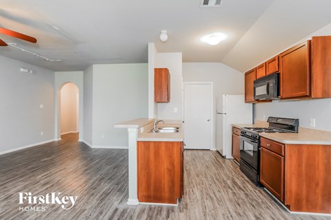 A kitchen with wooden cabinets and a white island.