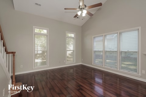 a living room with wood floors and a ceiling fan