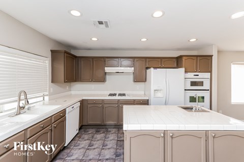 A kitchen with brown cabinets and white appliances.
