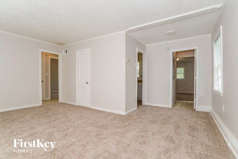 an empty living room with white walls and carpet