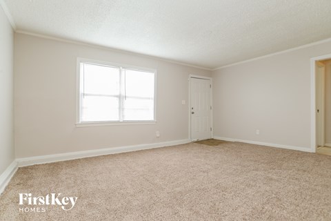 a bedroom with carpet and a window and a door