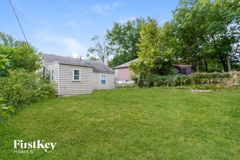 a backyard with a house and a yard with grass and trees
