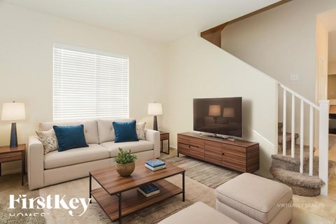 A living room with a couch, a coffee table, and a television.