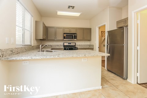 A kitchen with a granite countertop and stainless steel appliances.
