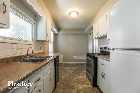 A kitchen with a sink, stove, and oven.