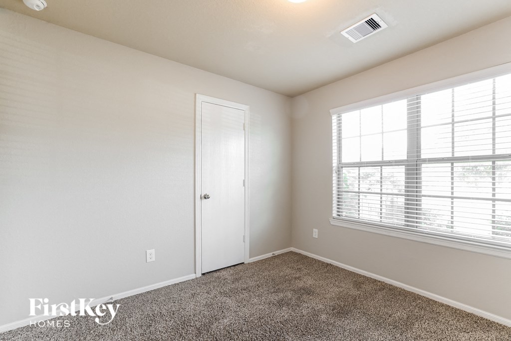 a bedroom with a carpeted floor and a large window
