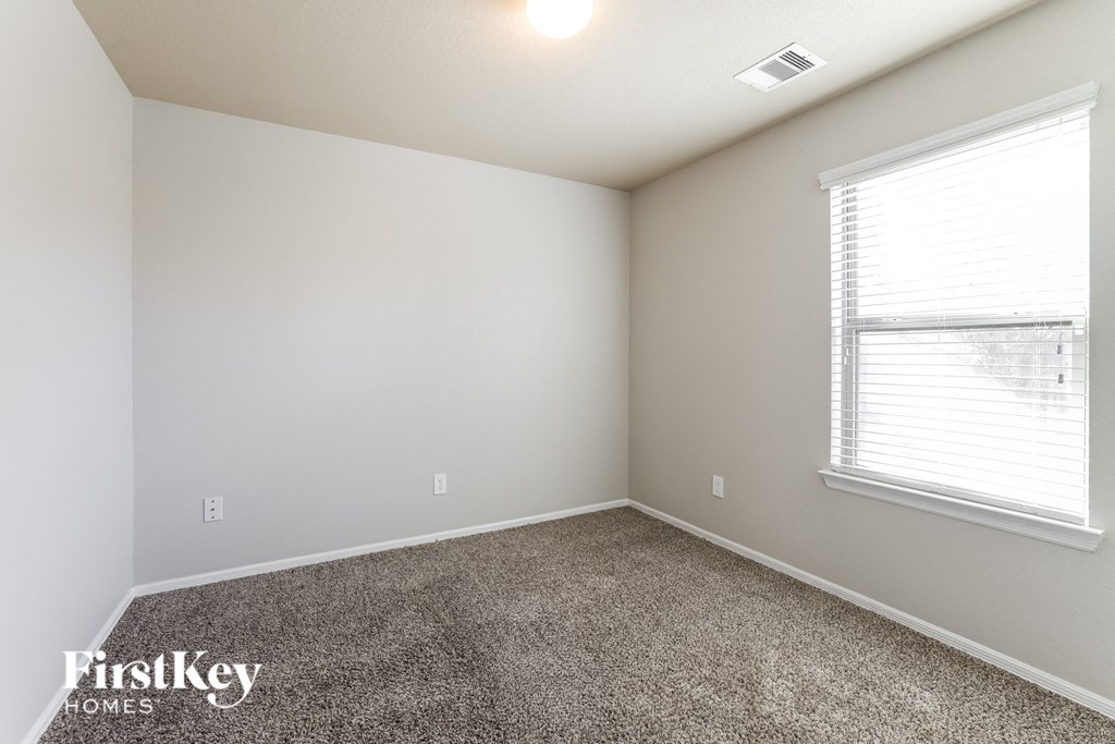 a bedroom with a carpeted floor and a large window