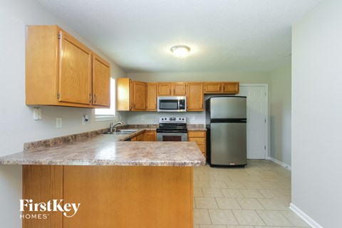 A kitchen with wooden cabinets and a granite countertop.