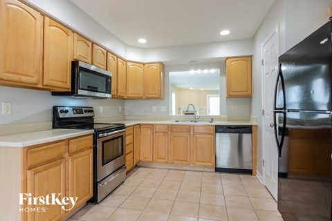 A kitchen with wooden cabinets and black appliances.