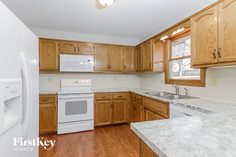 A kitchen with wooden cabinets and a white fridge.