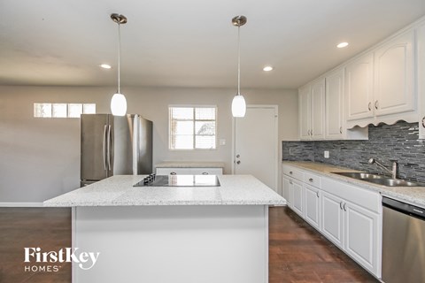 a white kitchen with stainless steel appliances and white counter tops