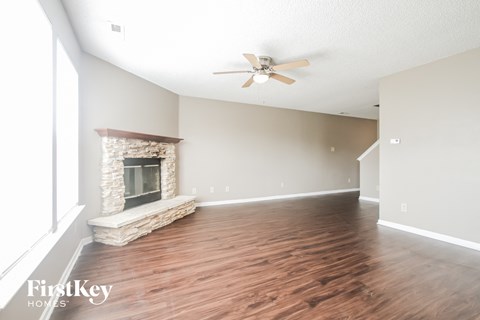 a living room with a fireplace and a ceiling fan