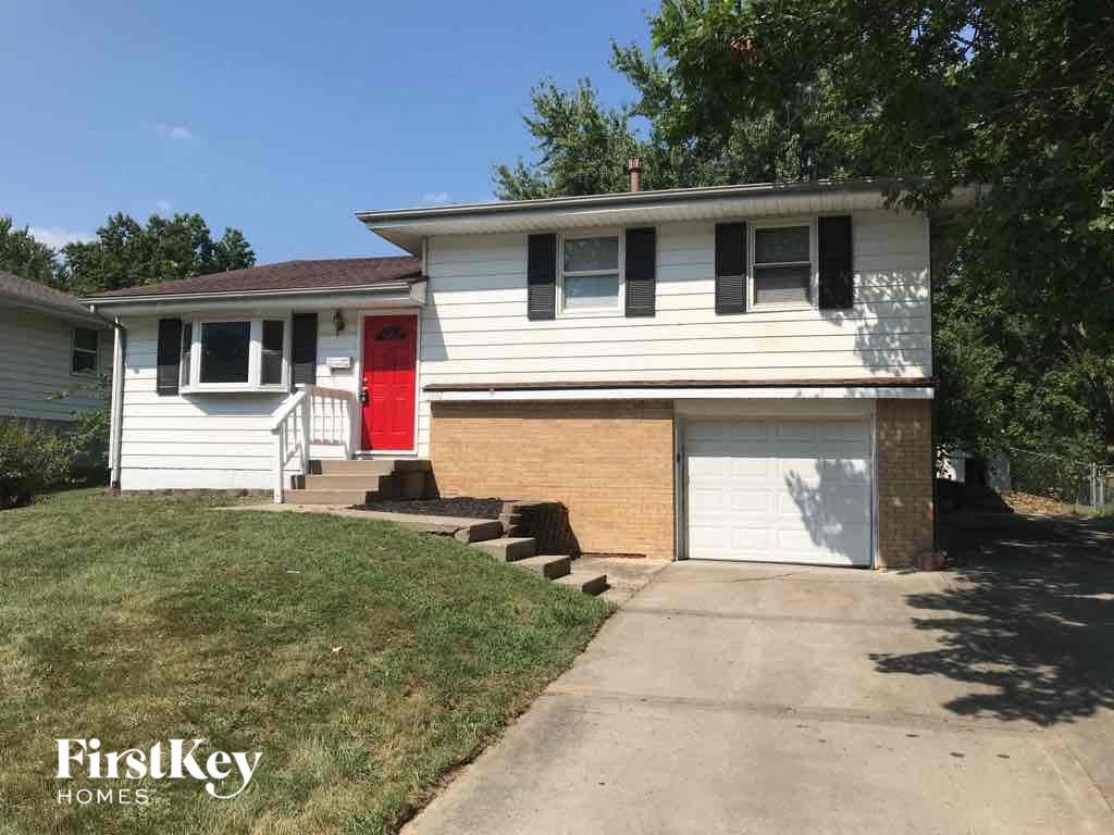 A two-story house with a red door and a garage.