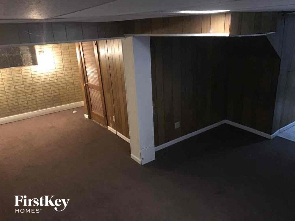 A room with a wooden floor and a wall with a light switch.