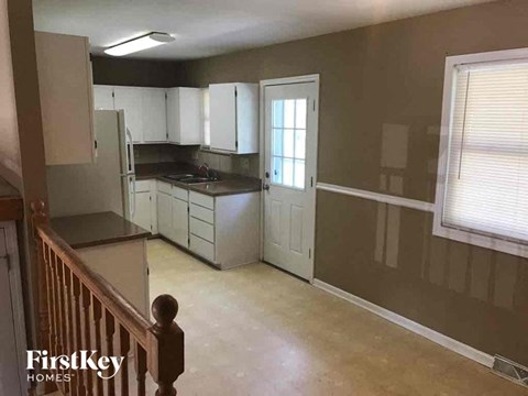 A kitchen with white cabinets and a black countertop.